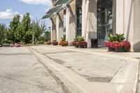 several flower pots sit in front of this very elegant building on the sidewalk outside the window