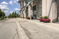 several flower pots sit in front of this very elegant building on the sidewalk outside the window