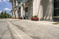 several flower pots sit in front of this very elegant building on the sidewalk outside the window