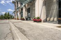 several flower pots sit in front of this very elegant building on the sidewalk outside the window