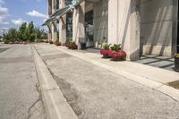 several flower pots sit in front of this very elegant building on the sidewalk outside the window