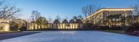 the entrance and walkway of an elegant home lit by led lights at dusk in front of a long rectangular wall