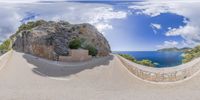 a fish - eye lens shot of an off road with the ocean in the background