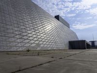 a large building with a roof made out of glass blocks is on a plain, the sky is blue