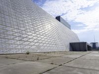 a large building with a roof made out of glass blocks is on a plain, the sky is blue