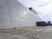 a large building with a roof made out of glass blocks is on a plain, the sky is blue