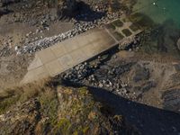 the small cement bridge has been built above the water to allow a walkway and a dock