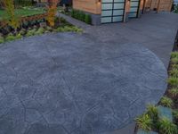 a cement patio with a large patio top on the side of it and green bushes around