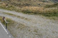 a motorcycle parked on a small mountain side road near mountains with no cars driving on it