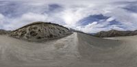 a fisheye image of some mountains and the sky with clouds in the background to show the landscape