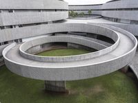 the building is designed like a spiral concrete structure with two smaller curved sections that are separated into two sides