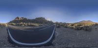 a street with no vehicles on it and mountains in the background, in this 360 - pano photograph