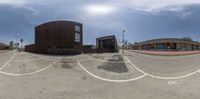 three fisheye lens photos of buildings in the street with a fence around it, and a bike path near by