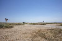 an empty open lot in a rural part of the world in the desert with two rusty road signs