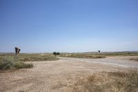 an empty open lot in a rural part of the world in the desert with two rusty road signs