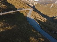 a bus driving down a road in front of mountains and rocks at sunset or sunrise or sunset