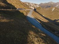 a bus driving down a road in front of mountains and rocks at sunset or sunrise or sunset