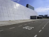 a white building with glass and metal blocks on it with no numbers for the bus riders