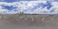 there is a 360 - zoom image of parking lot with a cloudy blue sky and a street light