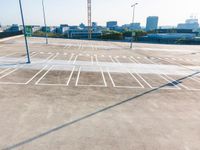 an empty parking lot with empty space on it in a city park and there are several different buildings in the background