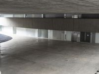 there are no cars in the parking garage this is a very long walkway and the garage floor was empty