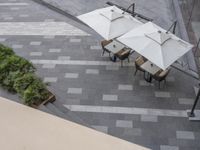 a table has four white umbrellas above it that look like chairs for sitting at them