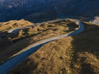 a view from the top of a mountain with a winding road in the foreground