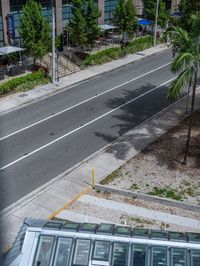 a long bus is traveling down the street by itself and it looks like he's going to work