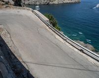 a paved road beside some large boats and a bridge with a bridge to the water