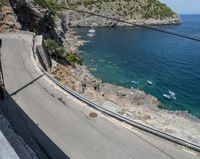 a paved road beside some large boats and a bridge with a bridge to the water