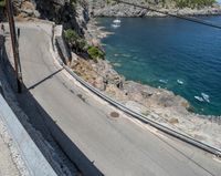 a paved road beside some large boats and a bridge with a bridge to the water