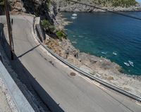 a paved road beside some large boats and a bridge with a bridge to the water