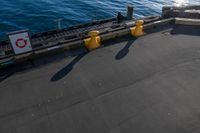 the view of a calm blue ocean and the sun reflecting on the water from the bow of a large boat