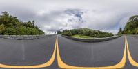 an upside down view of a road with three orange markers on it, and some trees in the distance