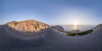 this is a panoramic photo of road and ocean view at sunset in mallorca, italy