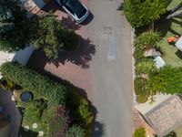 a view down on a residential neighborhood and parking lot from above, looking down onto a parking lot in the middle of it