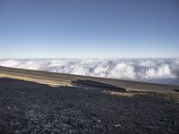 two lanes that are connected to each other with clouds above them on top of the mountain