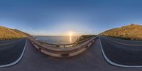 a 360 - view photo of the road that goes up a hill in front of the sea