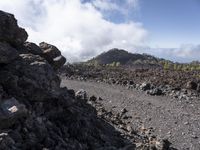 a rocky area that looks like lava in a mountain in the distance is a forested forest