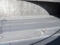 a concrete wall with shadows on it and a street intersection with no cars in it