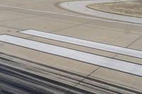 a runway with a plane wing with four white lines at the top and bottom of it