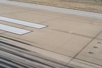 a runway with a plane wing with four white lines at the top and bottom of it