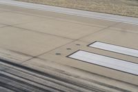 a runway with a plane wing with four white lines at the top and bottom of it