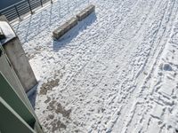 a skiier riding over the top of a ramp on a snowy day over a lake