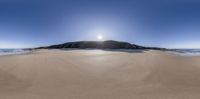 the beach is lined with sand and there are water coming up from the ocean and a small island in the distance