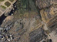 the aerial view of a beach and some rocks from above in the wild area of a coastal park