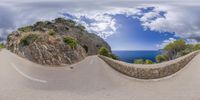 a fish - eye view of a paved road in the middle of some trees and mountains