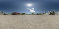 an empty concrete plaza is shown in a 360 - fish eye lens with bright blue skies