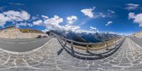 the view of a winding road through the mountains from a fisheye lens and some rocks