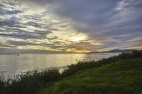 a large body of water with some boats sailing by it at sunset that appears to be in the ocean